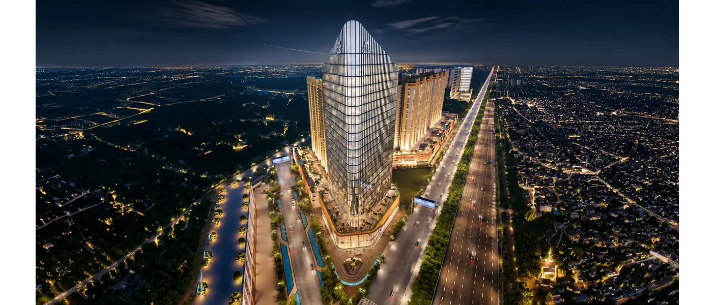 M3M CFC commercial tower in Gurgaon at night, illuminated against the city skyline with landscaped surroundings, connected roads, and nearby high-rise buildings.